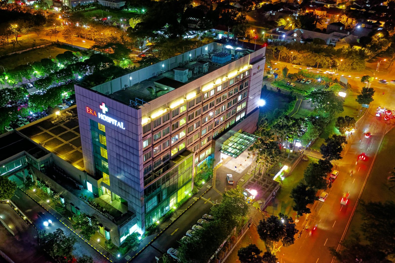 Stunning aerial view of Eka Hospital in Serpong, Indonesia, illuminated at night, capturing vibrant city lights and architecture.