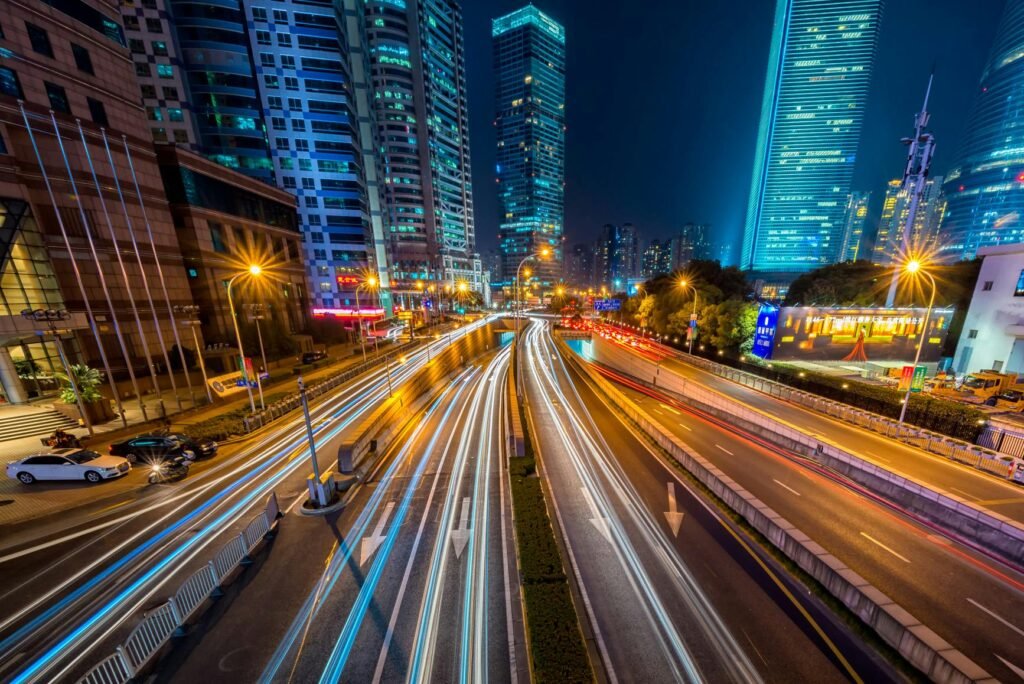 Dynamic long exposure night shot of urban cityscape with vibrant light trails and towering skyscrapers.